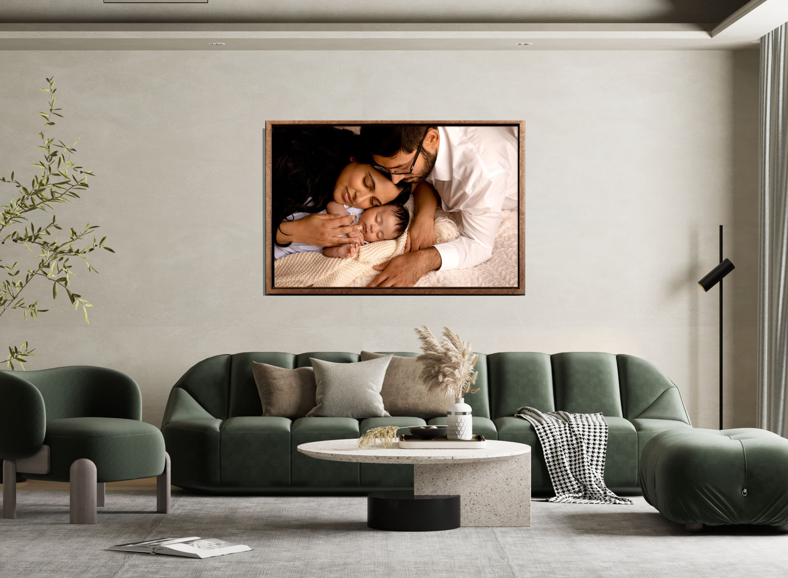 Mother and father warmly holding onto their newborn for a family and baby photoshoot. The pictures hanging on the wall shows that newborn memories are forever.