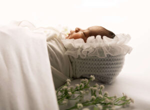 Tiny newborn baby, wrapped in cosy blankets, captured by chani spiro, the expert baby photographer.